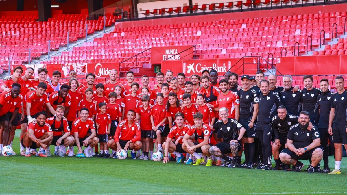 Lo jugadores del Sevilla posan con los capitanes de la cantera al término del entrenamiento
