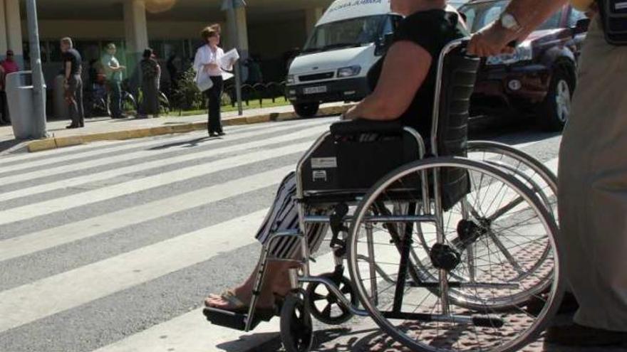 Barreras laborales. Una mujer minusválida cruza una calle.