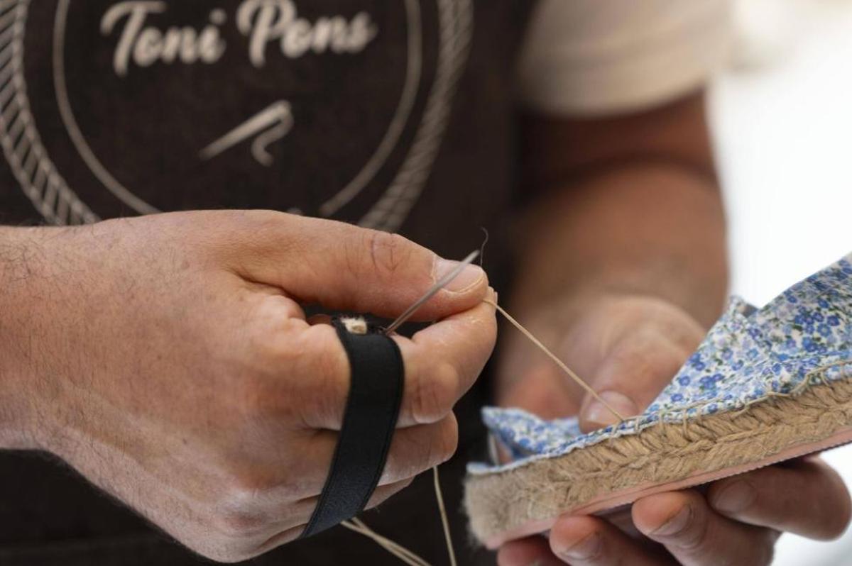 Un artesà cosint una espardenya