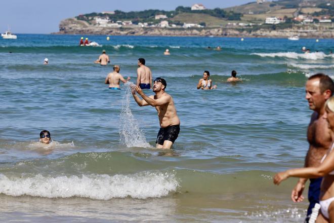 San Lorenzo se llena de bañistas para combatir el calor en Gijón: “Cuesta entrar, pero luego se está genial”