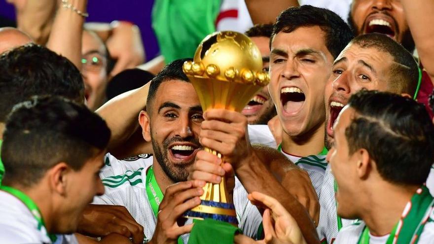 Aïssa Mandi, en el centro junto a Mahrez, con el trofeo de campeón de la Copa de África en 2019.