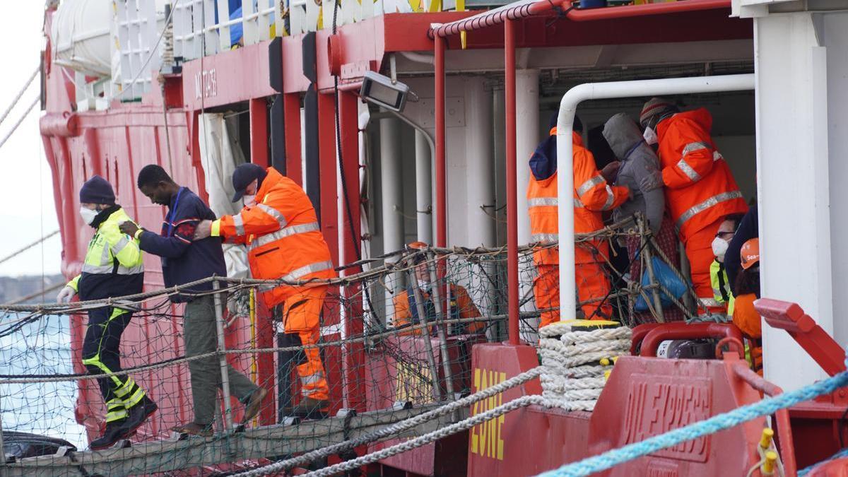 Unos migrantes son ayudados a desembarcar en el puerto de Nápoles tras ser rescatados en el Mediterráneo, el pasado mes de febrero.