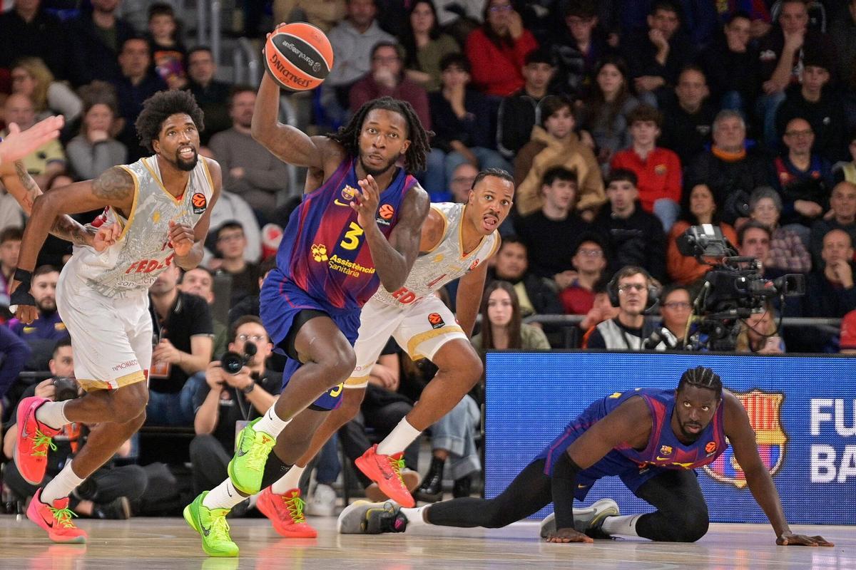 Myles Cale inicia un contraataque ante la mirada de Youssoupha Fall desde el suelo.