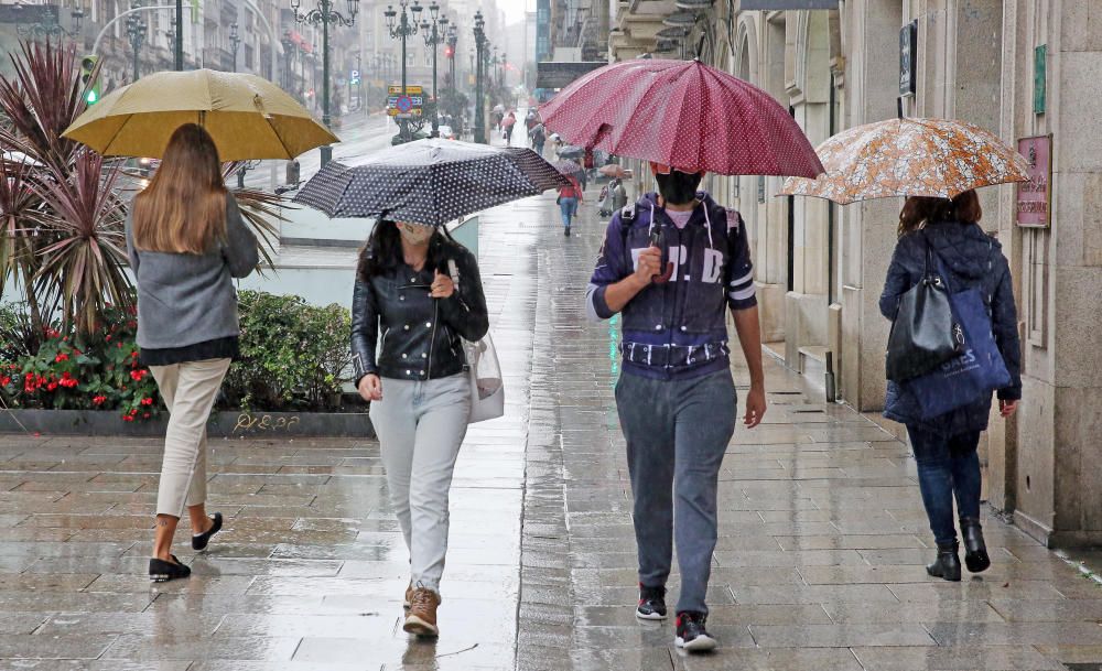 Los viandantes en el centro de Vigo se pertrecharon con paraguas