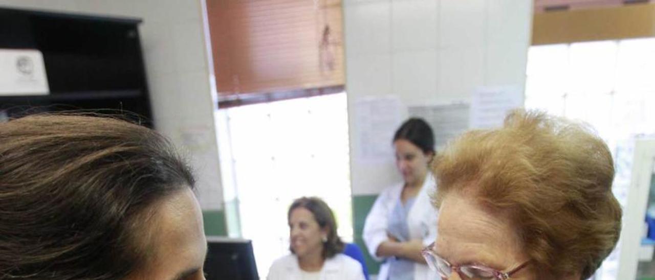 Una enfermera del centro de salud de Teatinos vacuna a una paciente contra la gripe.