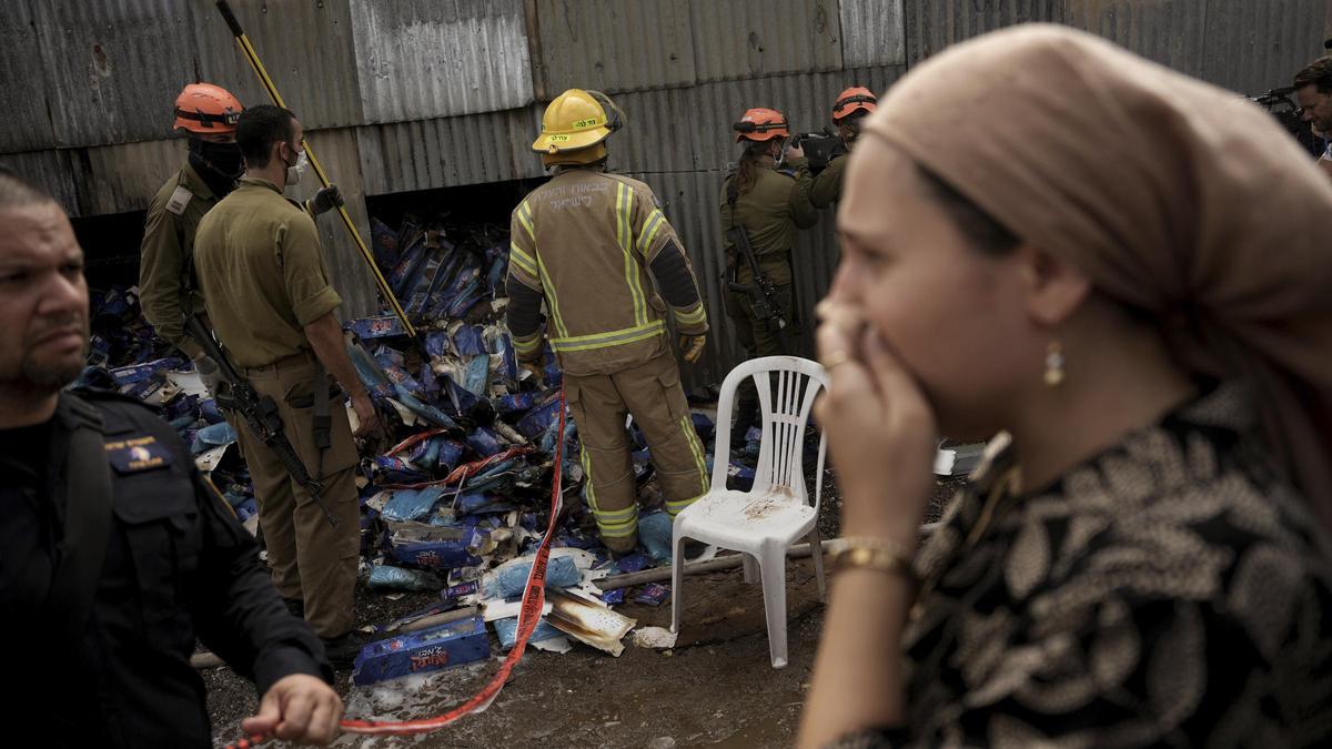 Personal de emergencias trabajan en el lugar en el que ha caído un cohete lanzado desde Gaza en Tel aviv, este lunes.