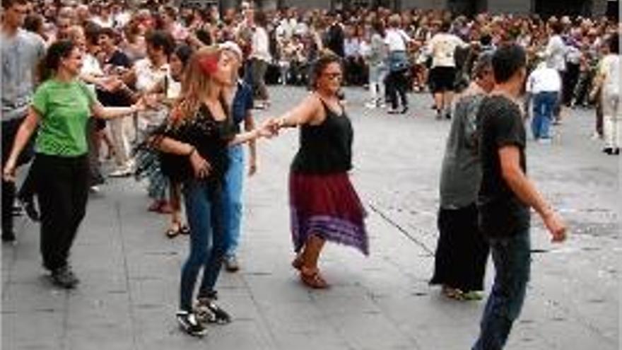 Parelles avancen amb passos de ball a través de la plaça.