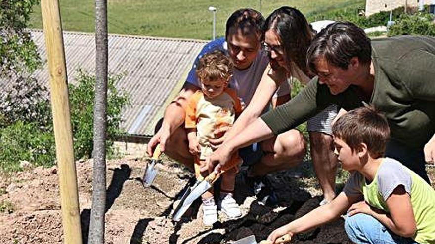 Una de les famílies fent la plantada de l&#039;arbre