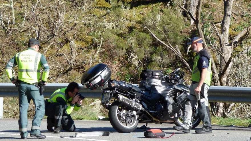 Agentes de la Guardia Civil de Tráfico inspeccionan la moto del fallecido, en Cangas del Narcea.