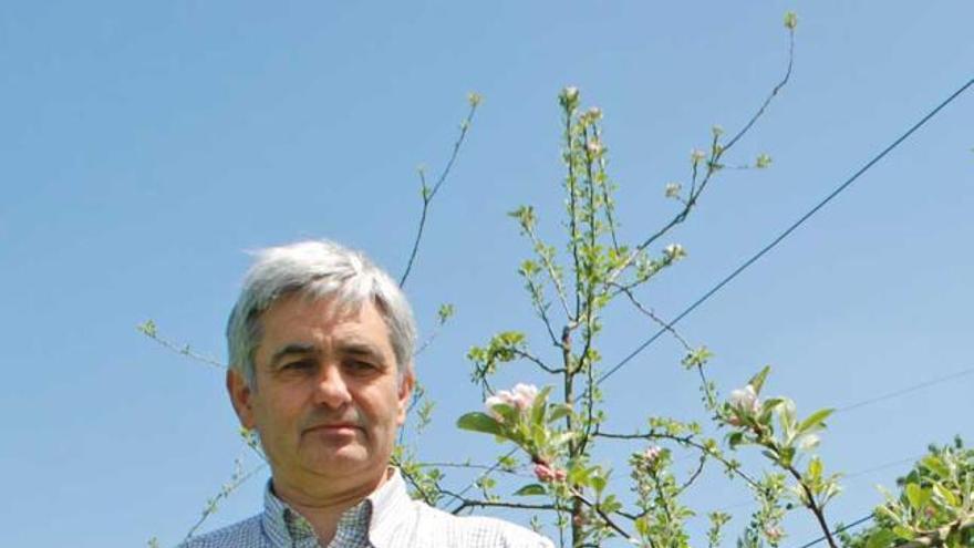 Enrique Dapena, junto a un manzano en flor, en la finca del Serida.