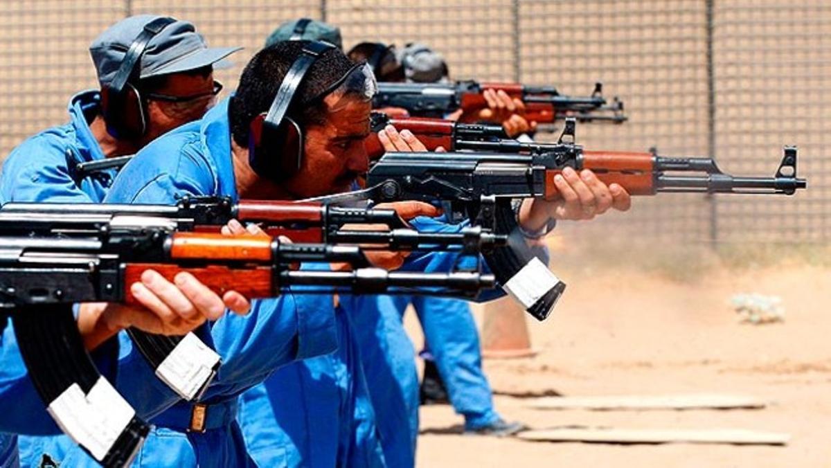 Un grup de policies afganesos dispara els seus fusells durant un entrenament amb un instructor canadenc en el camp de tir de Kandahar.