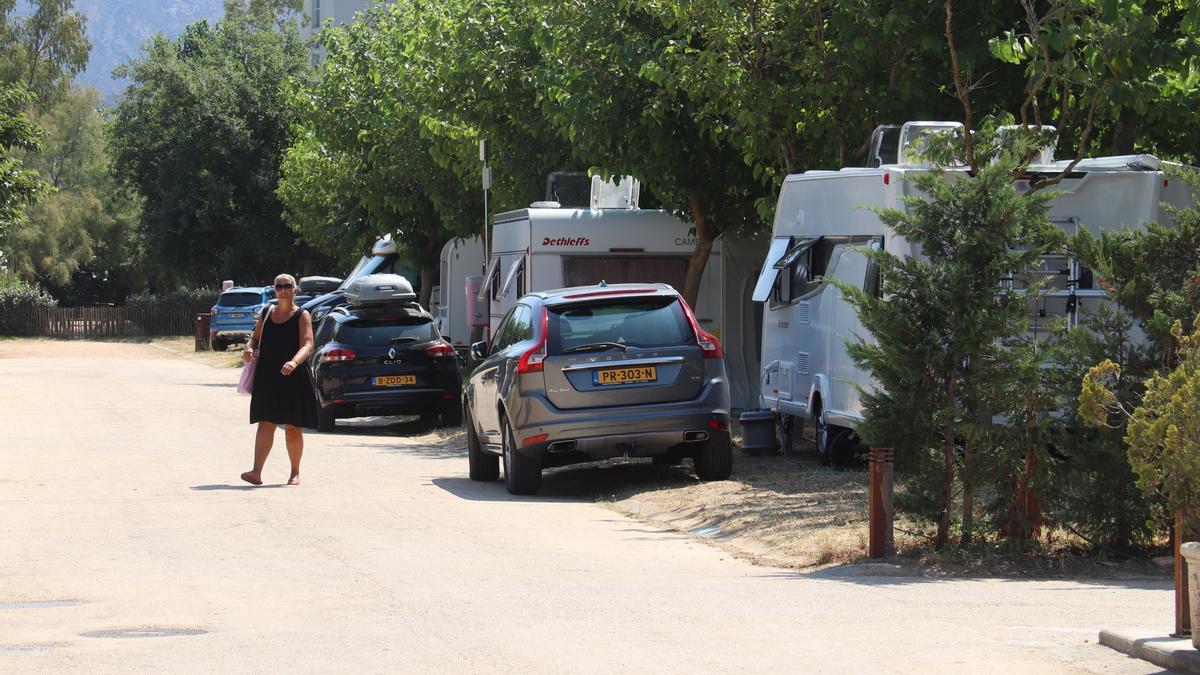 Pla obert de diverses caravanes aparcades al càmping Salatà de Roses amb una campista creuant el carrer el 29 de juliol de 2021. (Horitzontal)