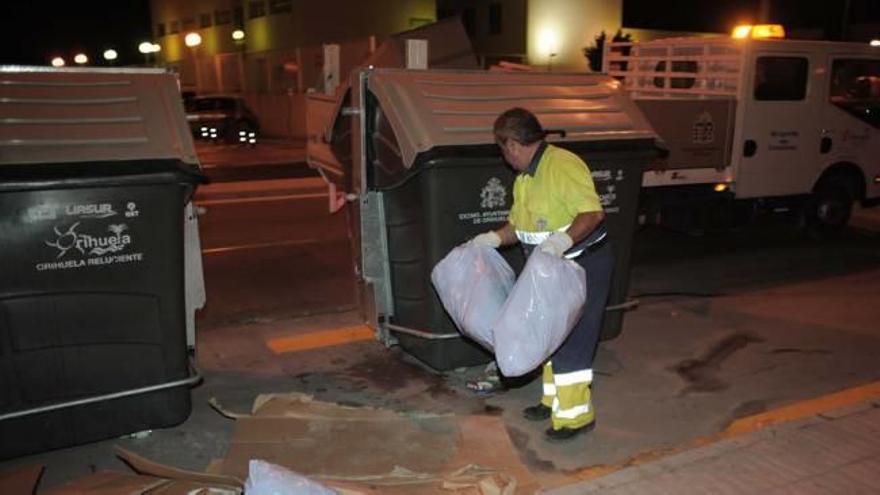 Imagen de uno de los operarios de la recogida de residuos prestando servicio en una calle del municipio de Orihuela.