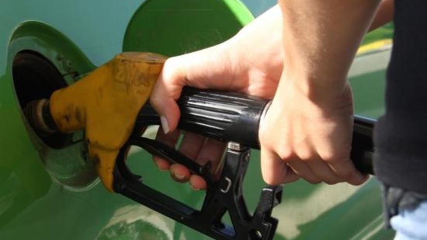 A la imatge un conductor posant gasolina al seu vehicle