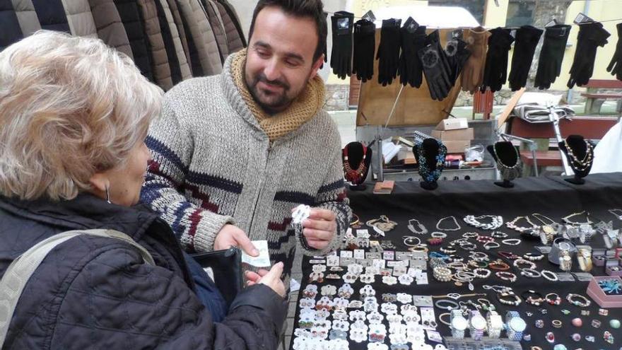 Mari Ruiz compra unos pendientes en el puesto del ovetense Luis Borgas, ayer, en Candás.