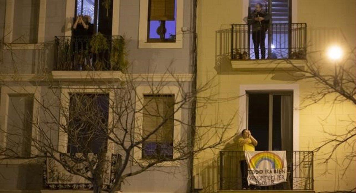 Vecinos aplauden a los sanitarios en la plaza de Joanic, en Barcelona.