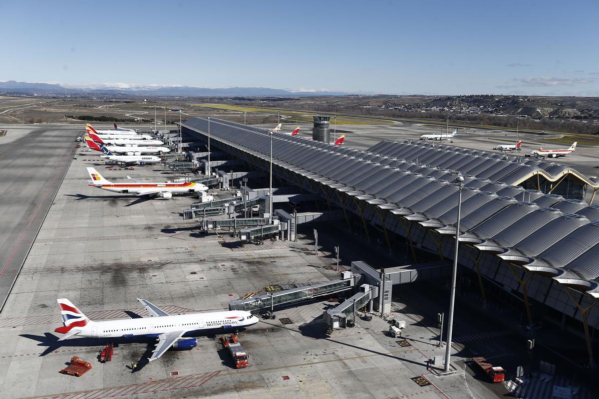 Varios aviones estacionados en un aeropuerto.