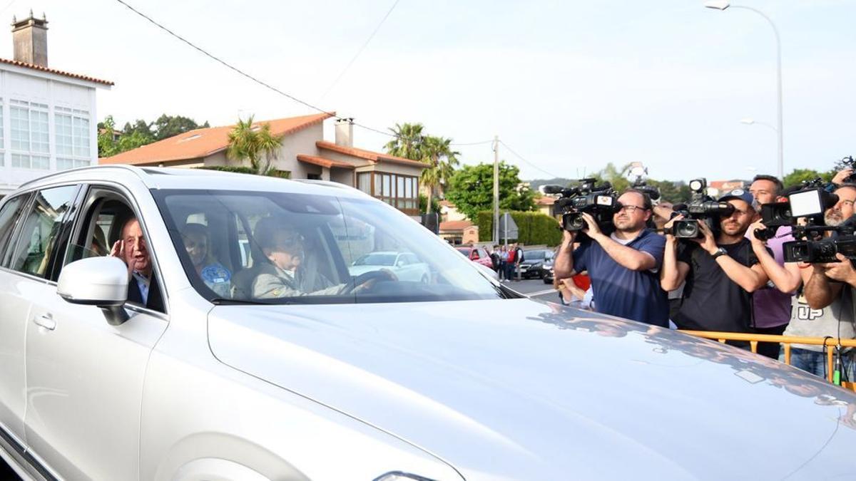 El rey emérito saluda al entrar hacia la casa de Pedro Campos, al volante de su coche, ayer en Nanín, Sanxenxo. / GUSTAVO SANTOS