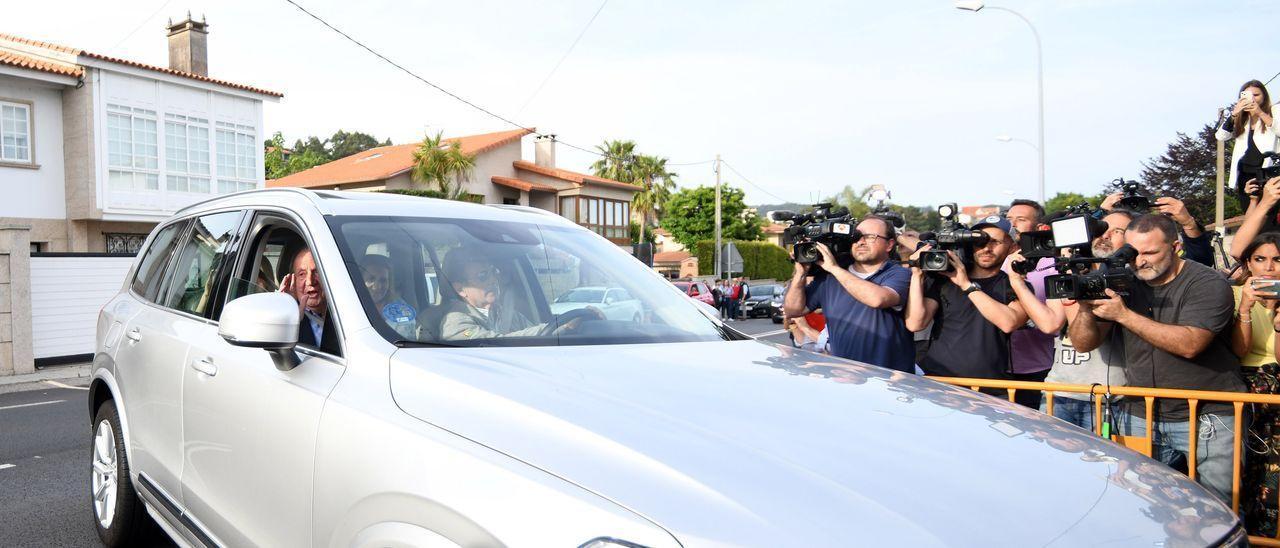 El rey emérito saluda al entrar hacia la casa de Pedro Campos, al volante de su coche, ayer en Nanín, Sanxenxo. / GUSTAVO SANTOS