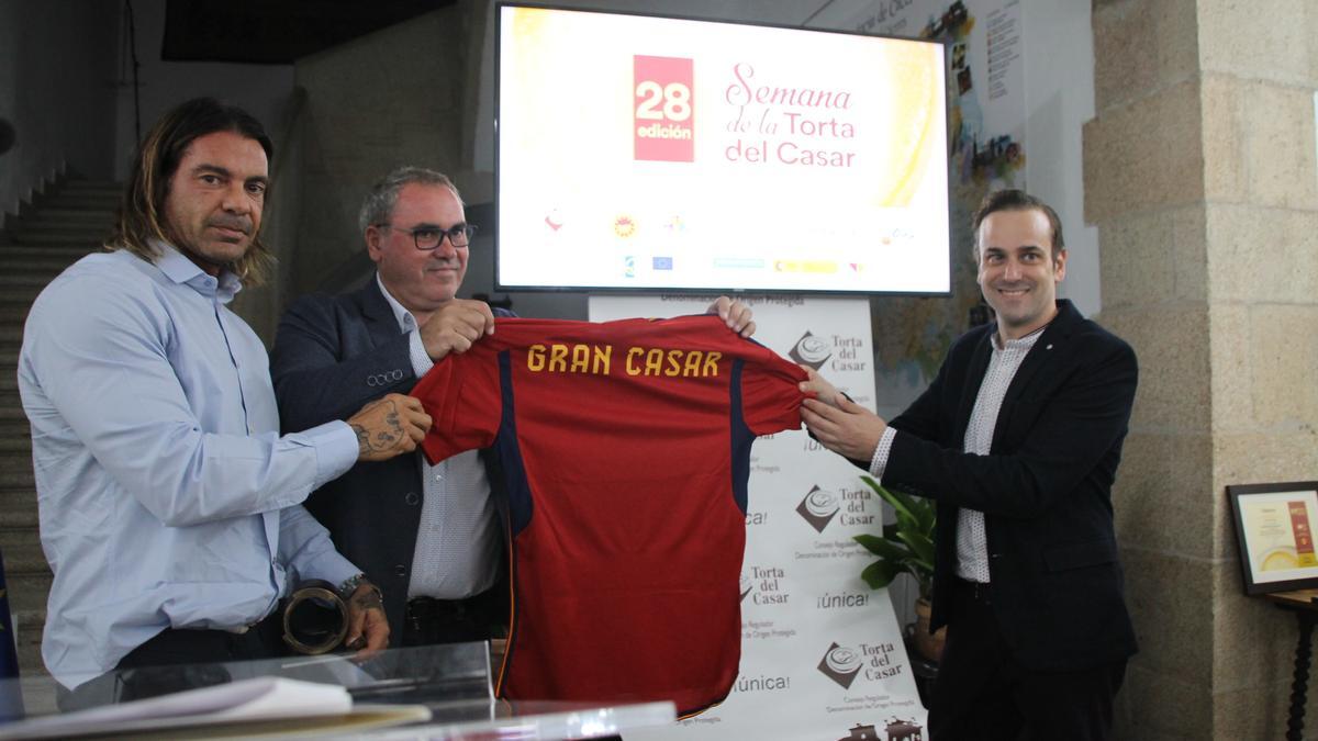 Félix Sánchez, de El Gourmet de La Roja, entrega a Ángel Pacheco, presidente de Torta del Casar, la camiseta de La Roja.