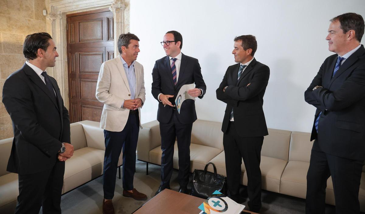 Lluís Noguera conversa con Carlos Mazón ante el director general de Energía, Manuel Arguellas, y otros miembros de la firma.