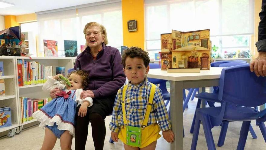 Carmina Cordero, con los pequeños &quot;raitaninos&quot; Elsa Barraso y Carlos Mallada, ayer, en la biblioteca.