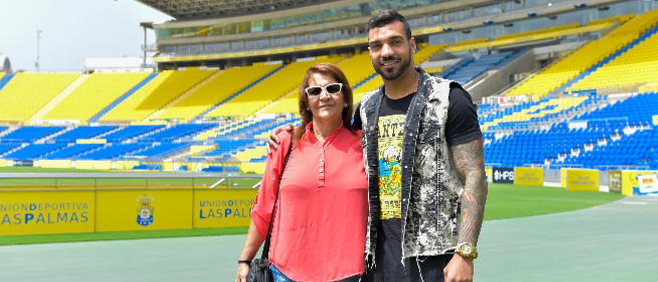 El nuevo lateral derecho de la UD, Michel Macedo, posa junto a su madre, Elizabeth, ayer, en el césped del Gran Canaria. Detrás, la Tribuna.