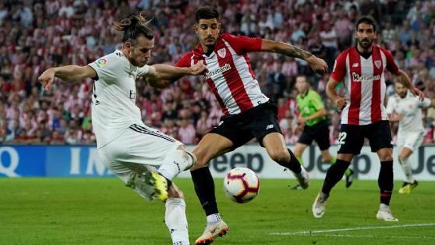 Yuri Berchiche intenta tapar l&#039;intent de rematada de Gareth Bale.