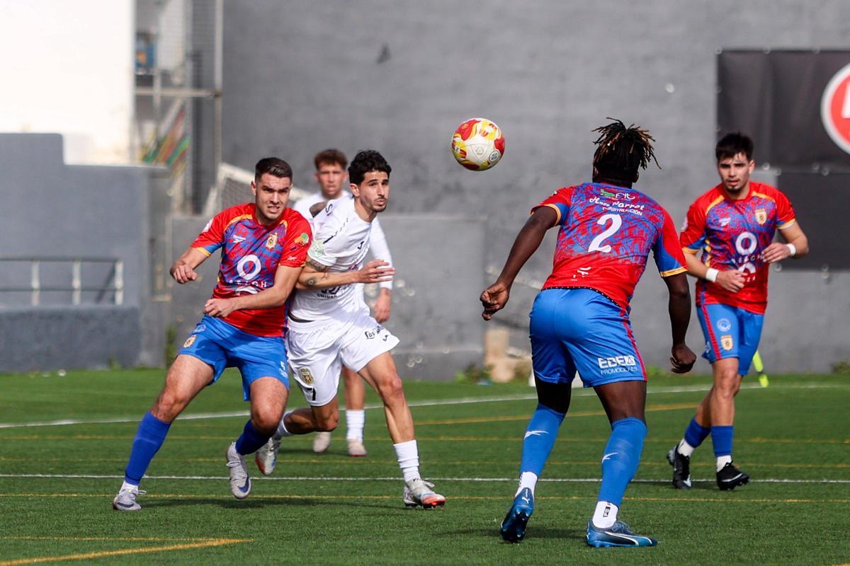 Dos jugadores luchan por el balón en el partido entre la Peña Deportiva y la SD Portmany