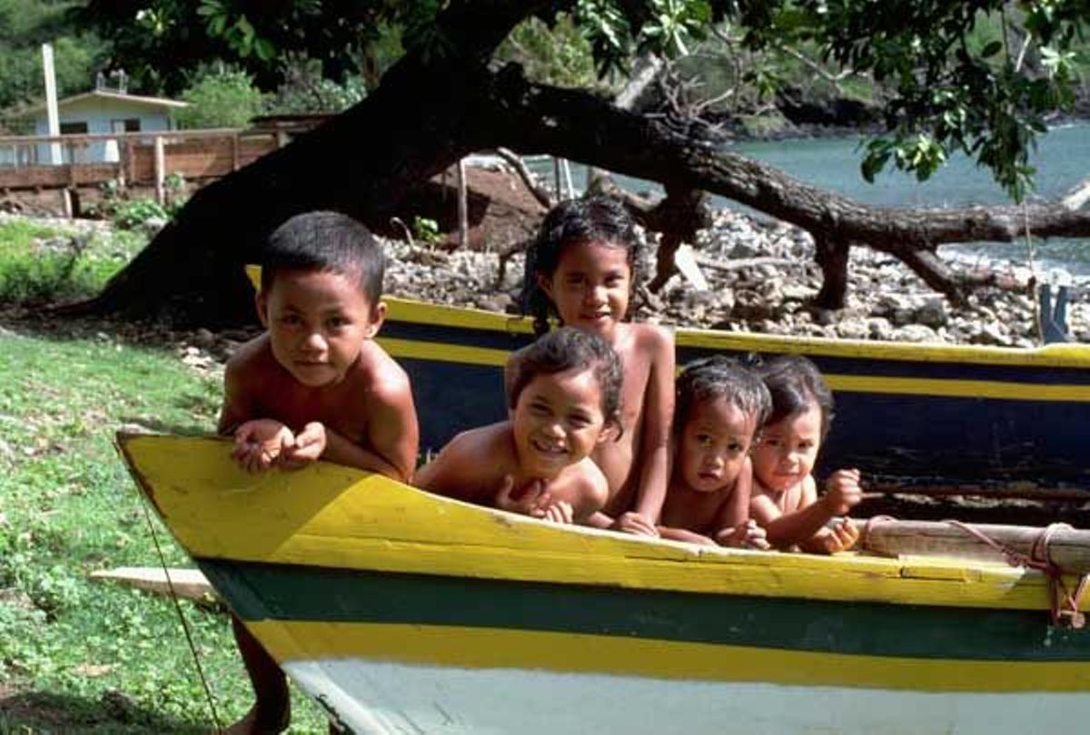 Niños en un canoa típica de las Islas Marquesas en la pequeña localidad de Vaitahu en la isla Tahuata.