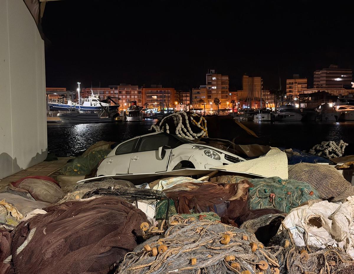 El coche afectado por la tromba marina junto a unas redes en el puerto pesquero de Mazarrón