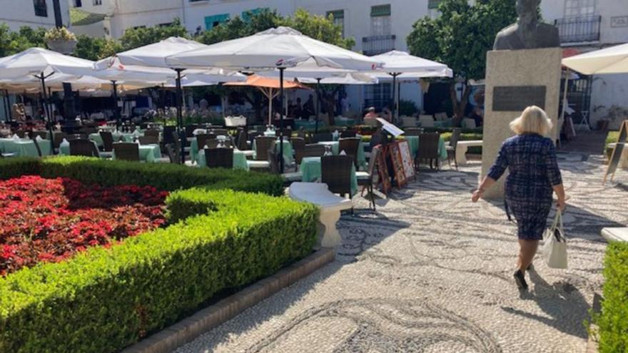 Una mujer cruza la plaza de Los Naranjos entre las mesas de varios locales. | L.O.