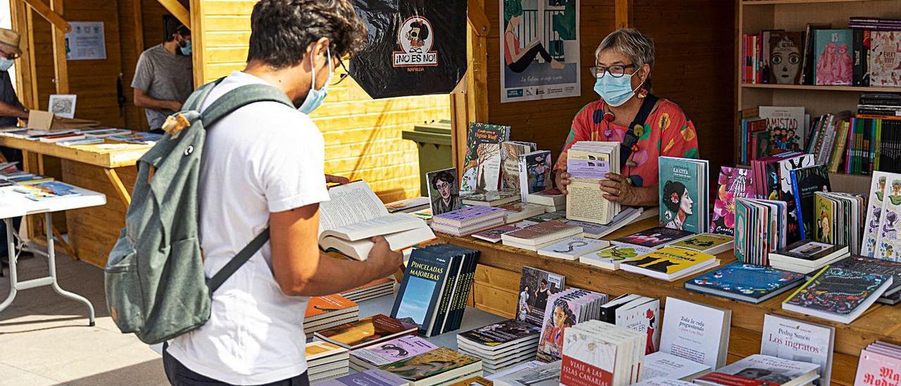 Un joven ojea un ejemplar en uno de los stand presentes en la Feria Insular del Libro, ayer.