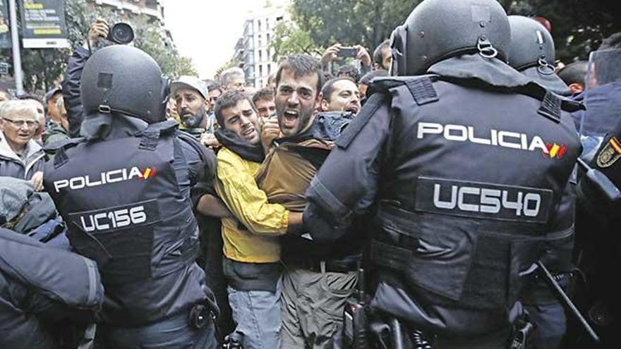 Agentes antidisturbios impiden que unos ciudadanos acudan a un colegio a votar el pasado domingo en Barcelona.