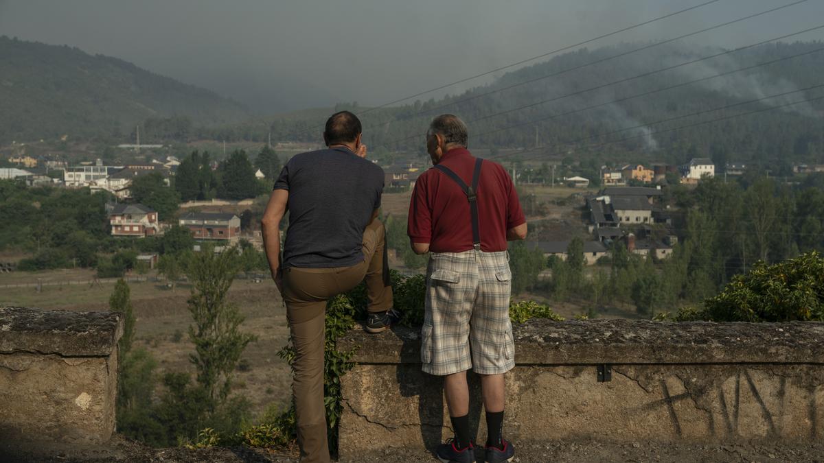 Dos vecinos observan el incendio de Valdeorras en Quereño, Rubiá, el último pueblo que estuvo en peligro.