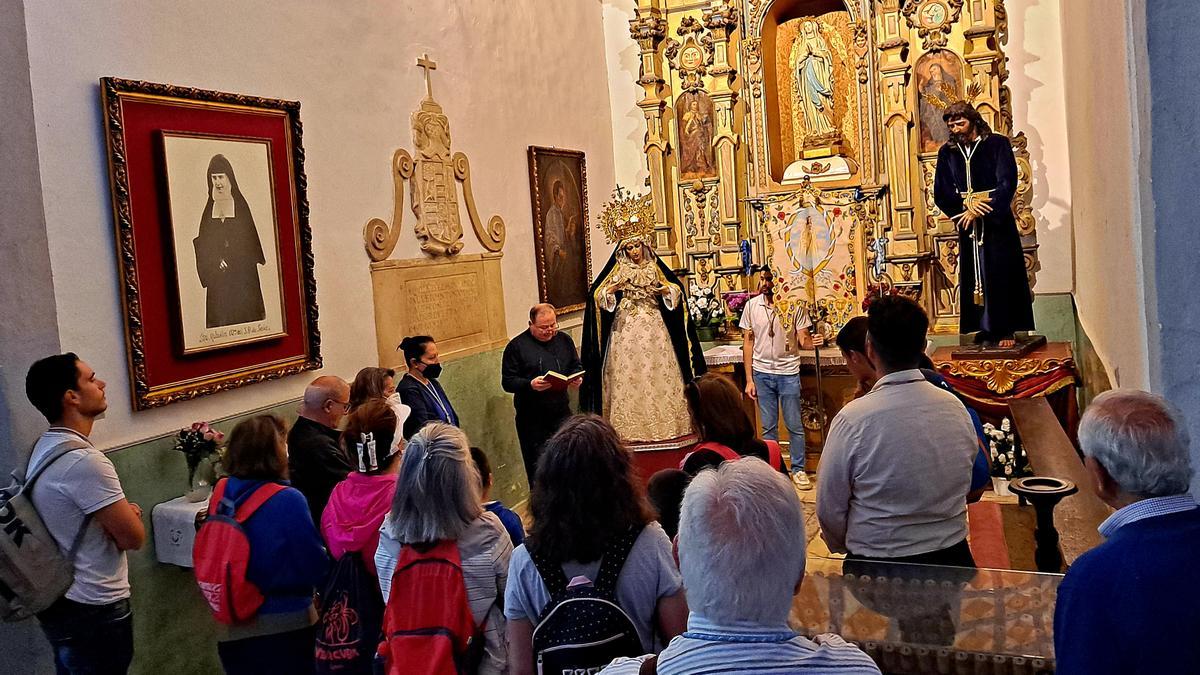 El párroco de San Agustín bendice a los peregrinos en la capilla donde están el Cristo Resucitado y la Virgen de la Aurora.