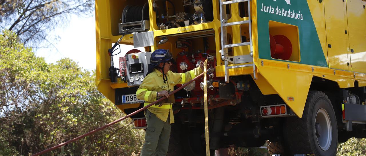 Un bombero junto a un vehículo de extinción de incendios en el Lagar de la Cruz, en Córdoba.