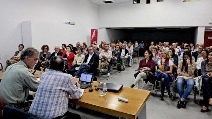 Mingotes, a la izquierda, con Luis Miguel Piñera, ante un salón de actos abarrotado de público.