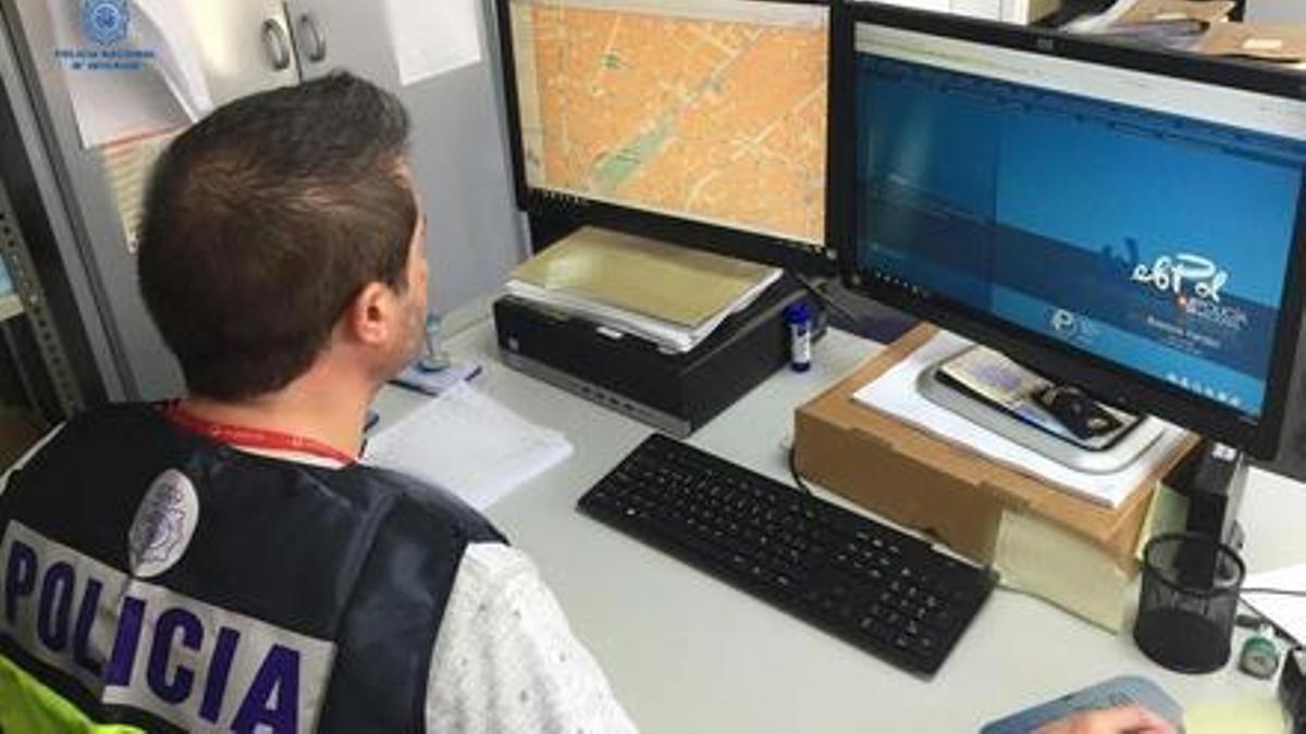Un policía nacional investiga ciberestafas en su ordenador.