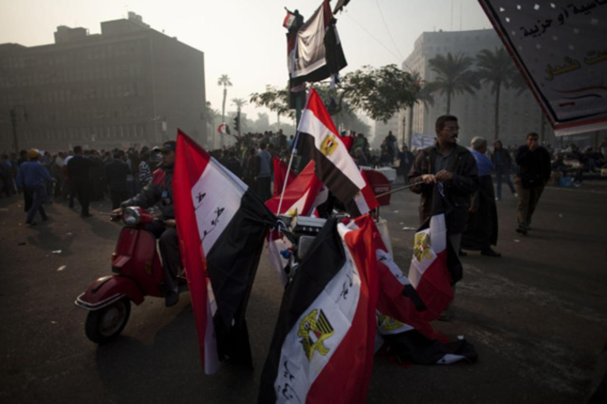 Un home ven banderes egípcies a la plaça de Tahrir al Caire (Egipte).