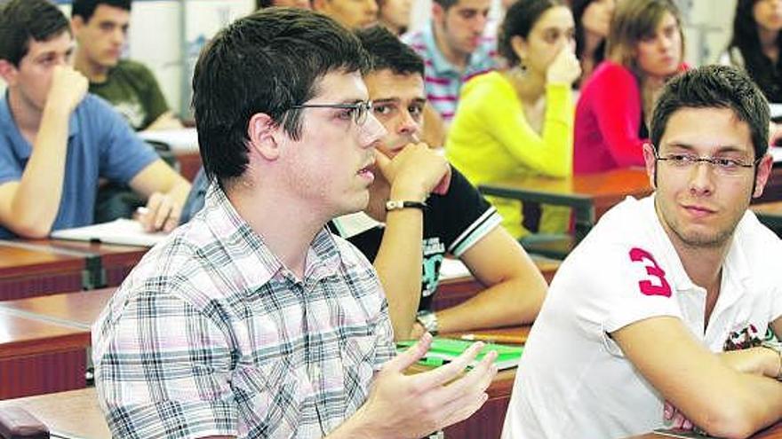 Arriba, Iván Grandío Quirós se dirige a Álvarez Areces, que aparece en la foto de abajo, con Mariano Abad (de pie) y con José Antonio Cecchini, vicerrector de Extensión Universitaria.