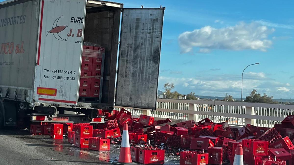 Las cajas de cerveza esparcidas por el asfalto después de que un camionero no asegurara la carga.