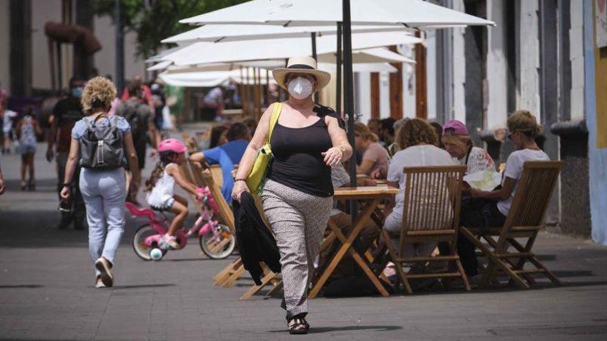 Una mujer pasea cerca de la terraza de un restaurante de La Laguna.