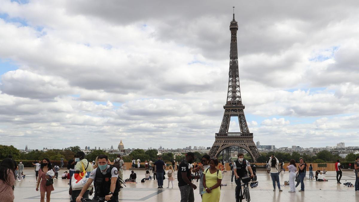 Ciudadanos pasean frente a la Torre Eiffel.