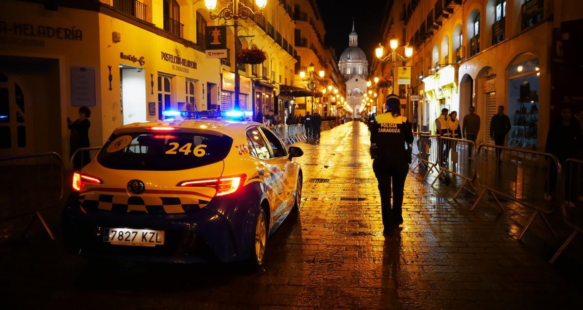 Una patrulla de la Policía Local de Zaragoza, en la calle Alfonso con el Pilar de fondo.