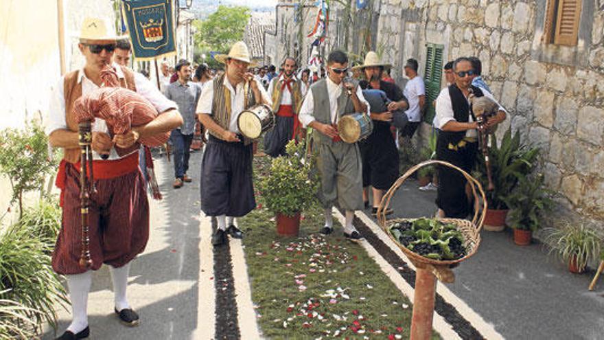 La comitiva del Fadrí Major pasa por el carrer Nou, decorado para la ocasión.