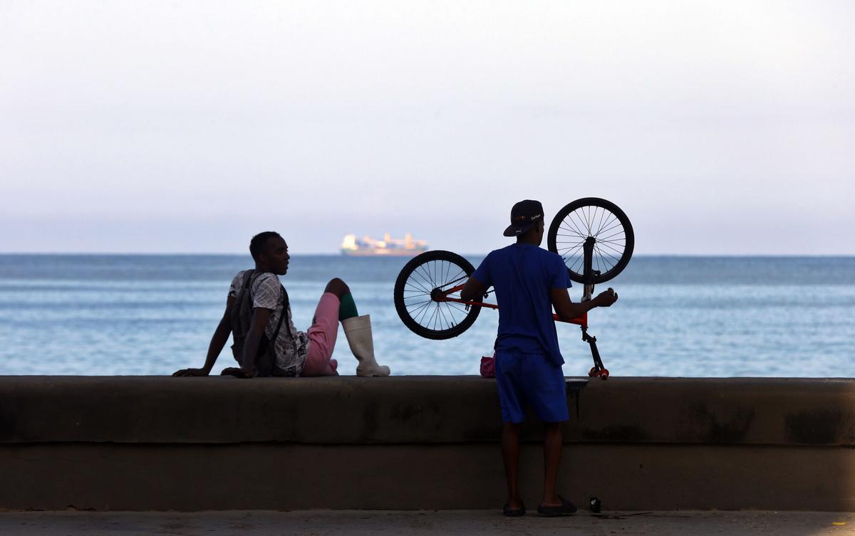 AME4946. LA HABANA (CUBA), 02/12/2025.- Personas observan el mar en una zona del malecón habanero este martes, en La Habana (Cuba). EFE/ Ernesto Mastrascusa