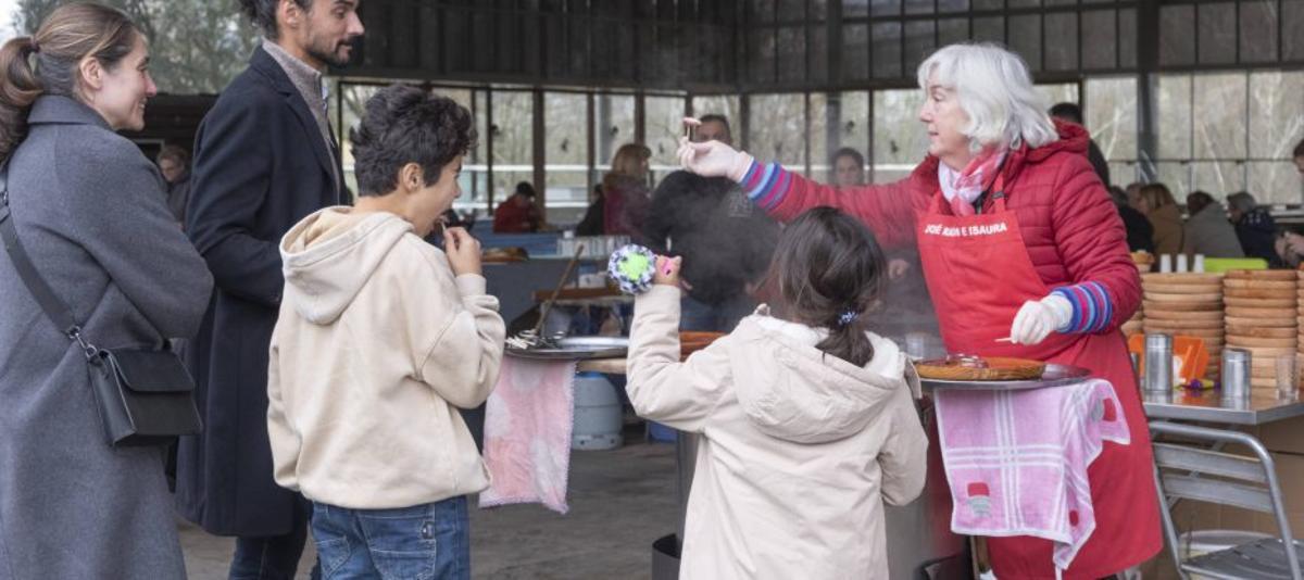 Isaura, dando a probar una «tallada» a los clientes. |  Roi Cruz