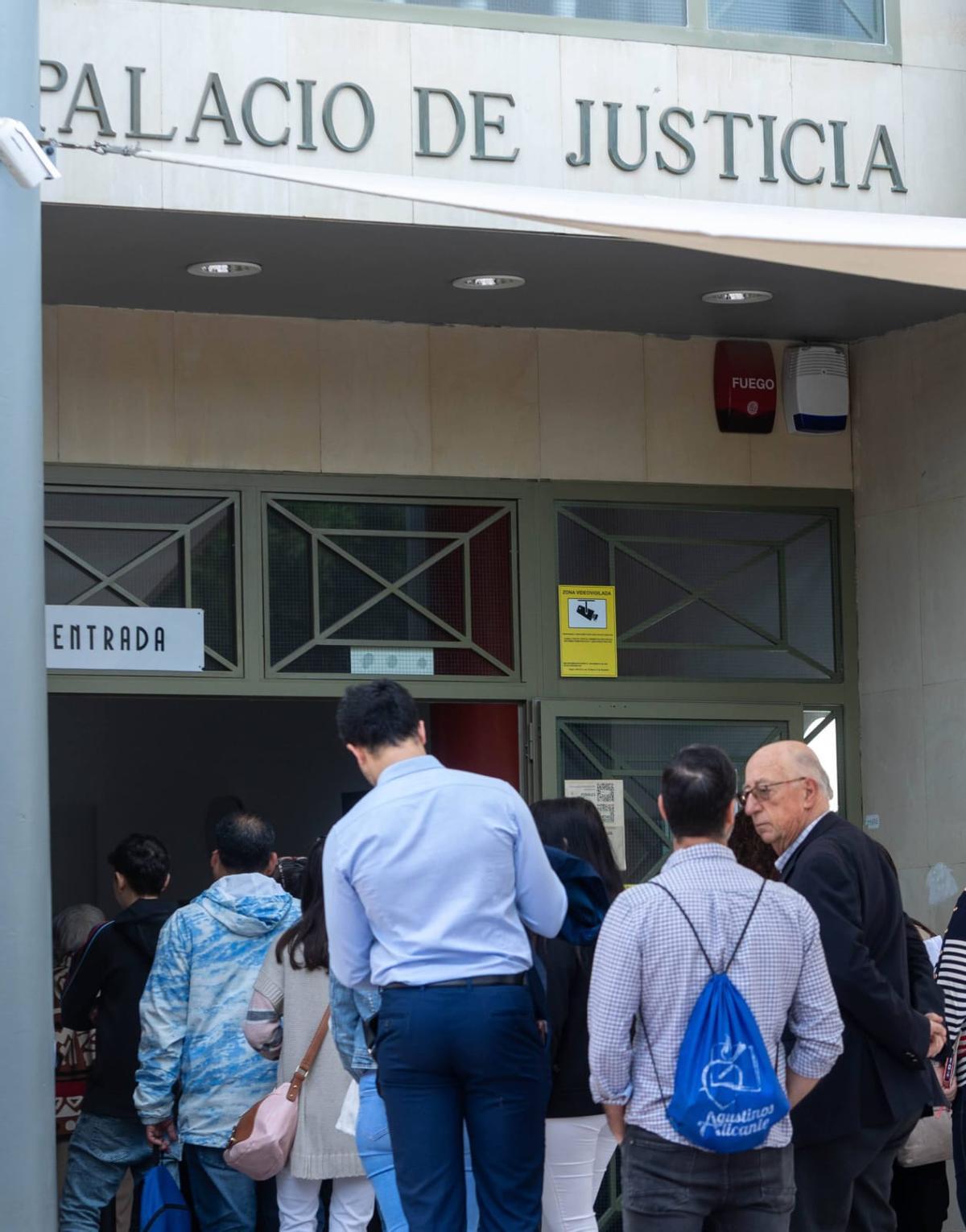 Julio de España, a la derecha de la imagen, se dispone a entrar al Palacio de Justicia para comparecer en el juzgado el pasado julio.