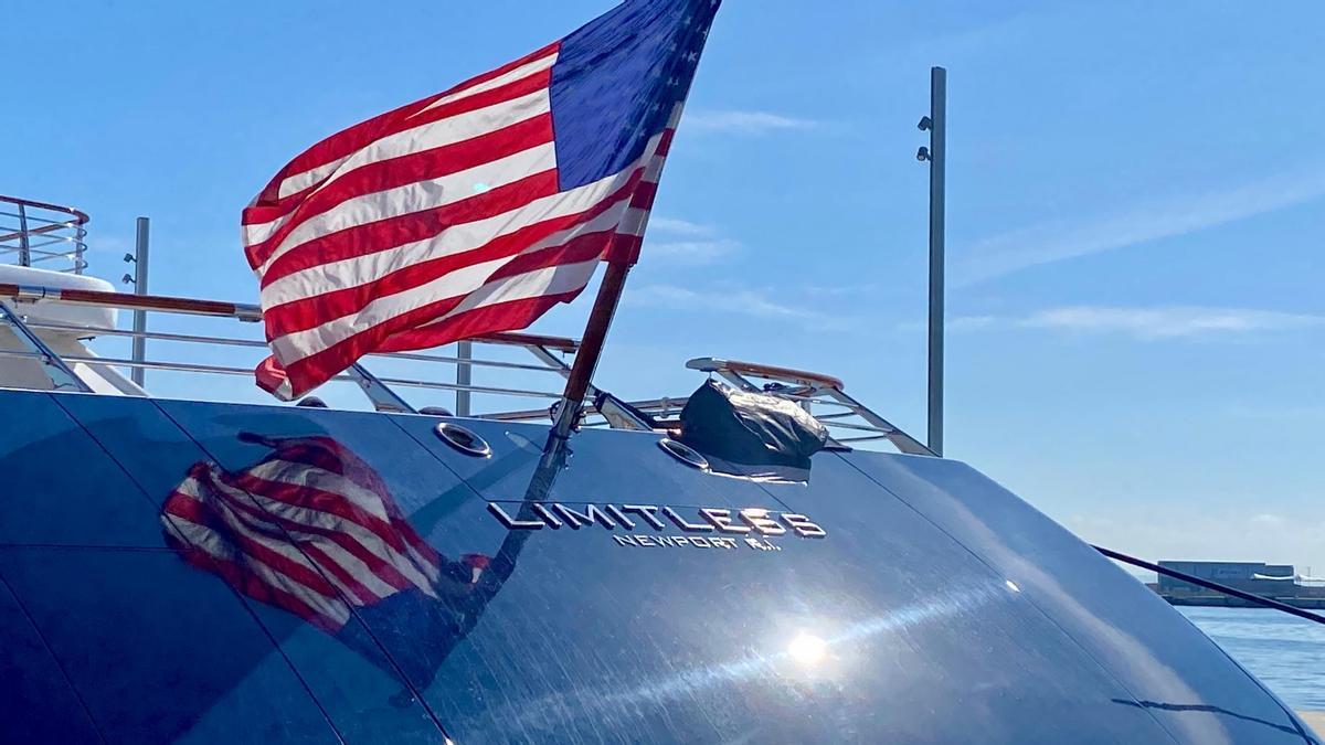 Imagen de la popa del yate Limitless en el Club de Mar con la bandera estadounidense
